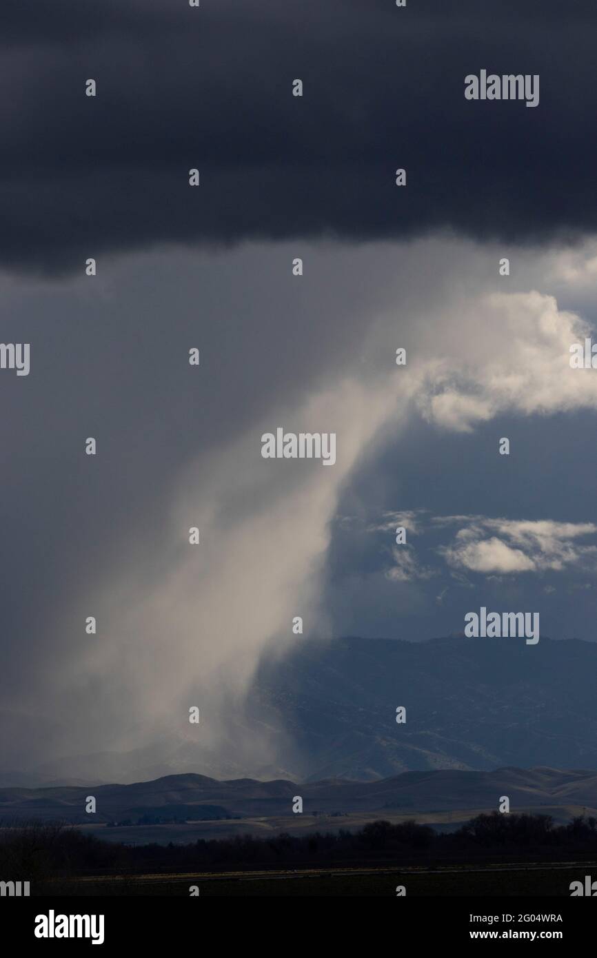 Un système de tempête de la fin de l'hiver produit des averses de pluie au-dessus de la chaîne côtière dans l'ouest du comté de Merced, dans la vallée de San Joaquin en Californie. Banque D'Images