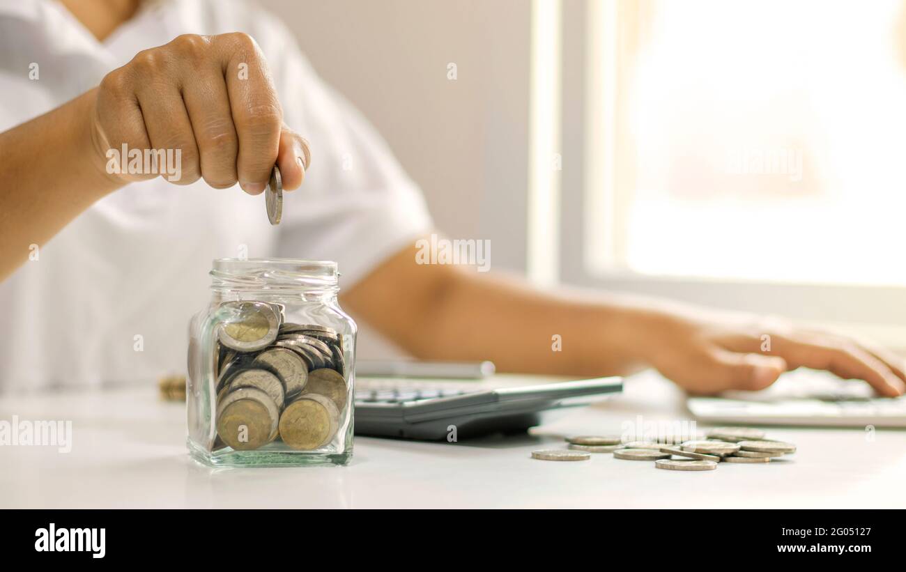 Les hommes d'affaires mettent des pièces de monnaie dans un pot d'épargne, y compris un centime croissant pour des idées d'affaires, financières et comptables. Banque D'Images