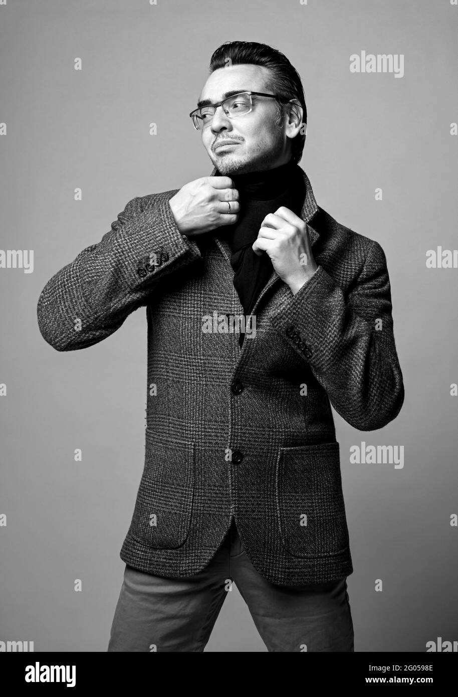 Portrait noir et blanc d'un homme d'affaires élégant en Jean, veste à  carreaux et foulard noir regardant de côté Photo Stock - Alamy