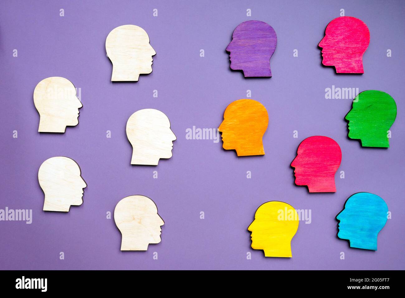 Des têtes en bois colorées symbolisant la diversité, la ségrégation et le racisme. Banque D'Images