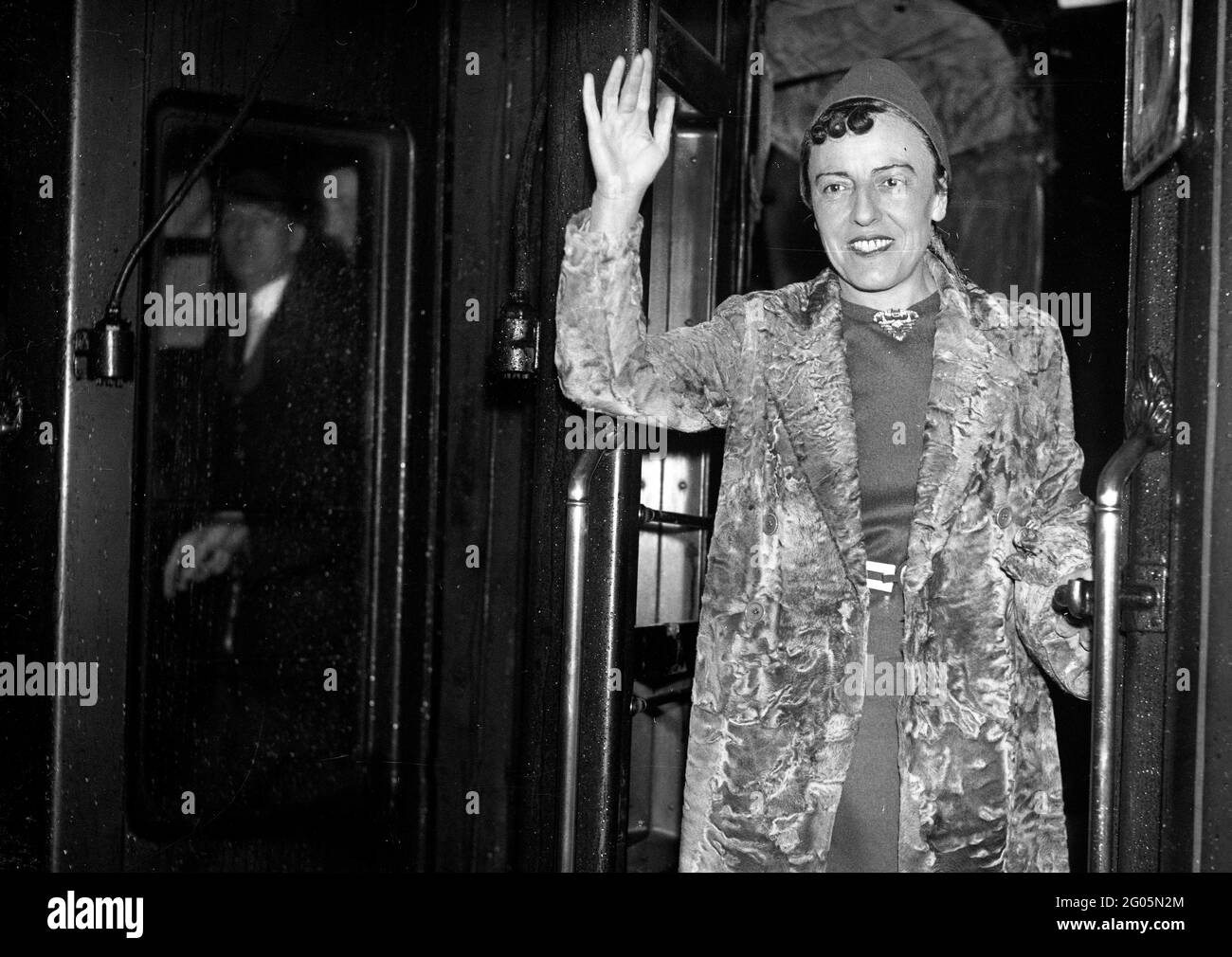 Embarquement à bord du train de bateau « RMS Queen Mary » pour sa première visite à la romancière et jouante anglaise américaine Dodie Smith (1896 - 1990) portant son manteau de fourrure de marque à la gare de Waterloo, Londres, 27 octobre 1937. Dorothy Gladys 'Dodie' Smith. Auteur des cent et un Dalmatiens. Fourrure mode Grande-Bretagne années 1930 1937 femmes femmes femmes femmes écrivain Kiss curl Kiss curls tendance flamboyant commode dressing femme actrice femme agitant train de prendre le départ Banque D'Images