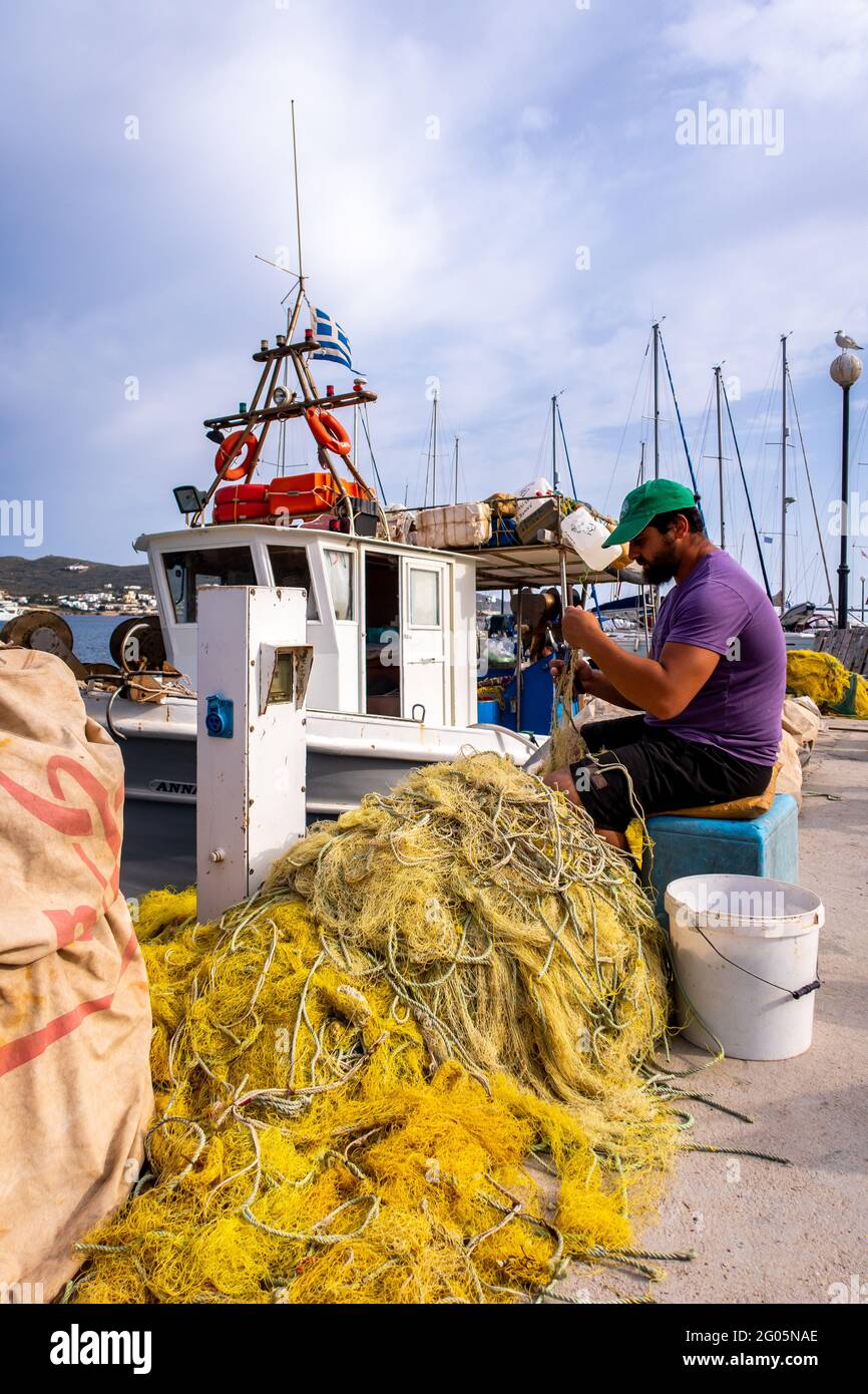 FINIKAS, SIROS, Grèce, 27.05.2019. Pêcheur grec réparant ses filets de pêche en nylon sur le quai de Port de Finikas sur l'île de Siros, Cyclades, Grèce. Banque D'Images