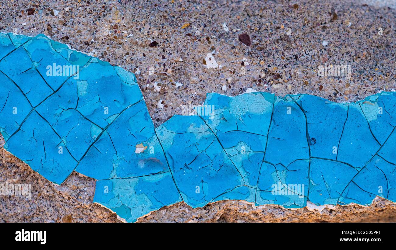 Peinture bleue sur le mur. Un vieux mur en béton avec de la peinture fissurée et écaillée. Surface peinte rugueuse et abîmé Banque D'Images