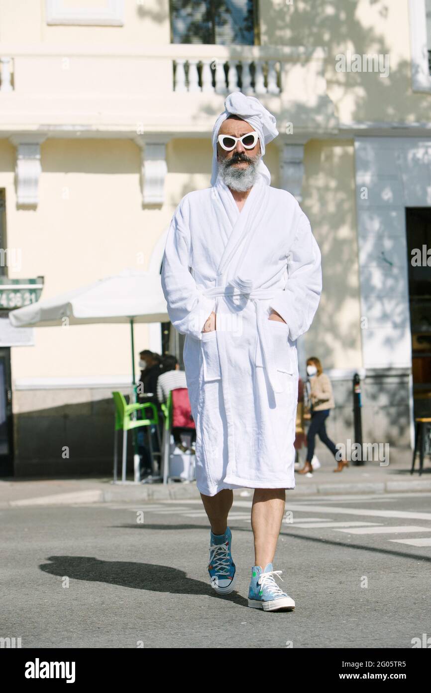 homme en peignoir traversant la rue Banque D'Images