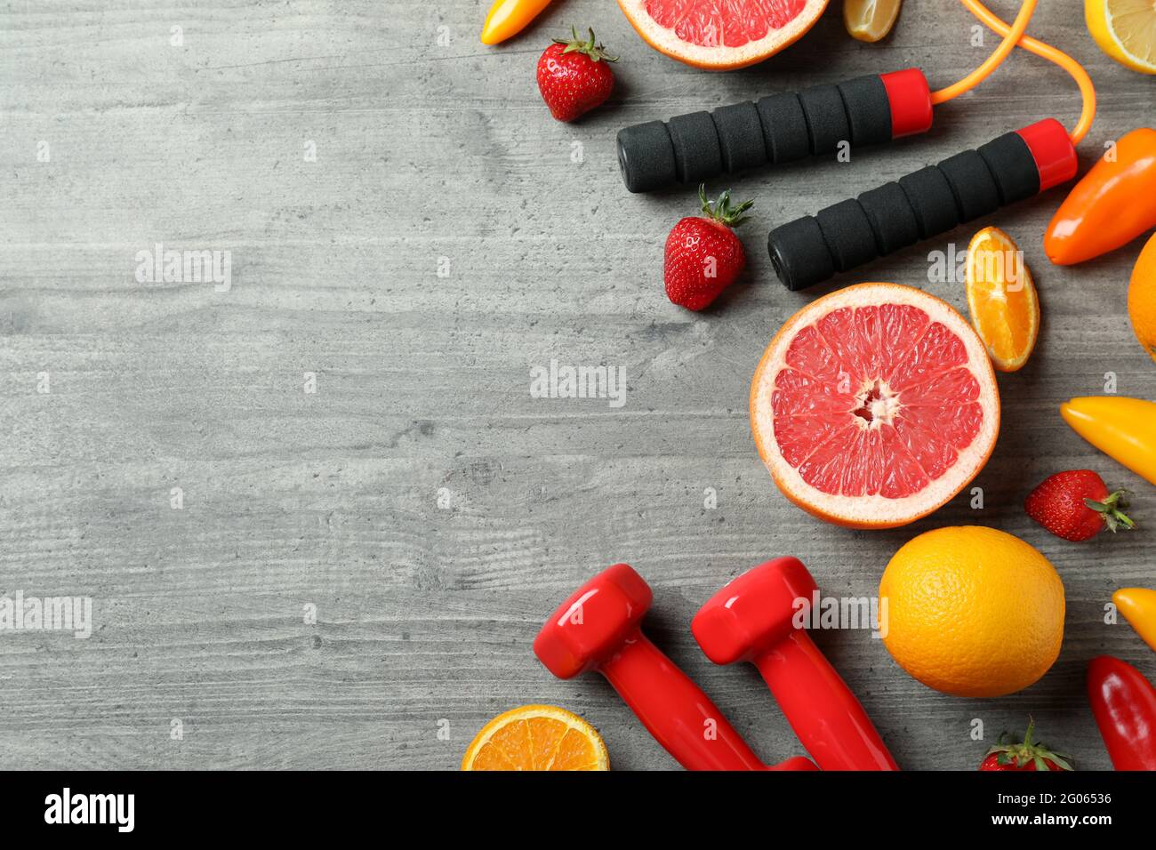 Nourriture saine, corde à sauter et haltères sur fond gris texturé Banque D'Images