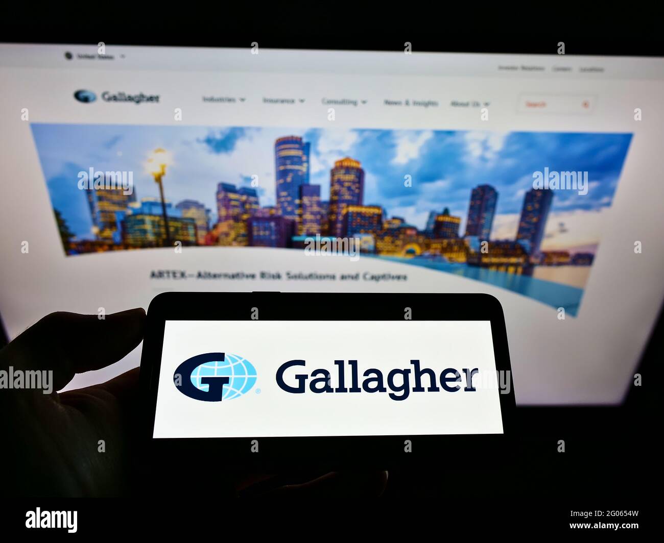 Personne tenant un téléphone portable avec le logo de la compagnie d'assurance américaine Arthur J. Gallagher Co. Sur l'écran devant le site Web d'affaires. Mise au point sur l'affichage du téléphone. Banque D'Images