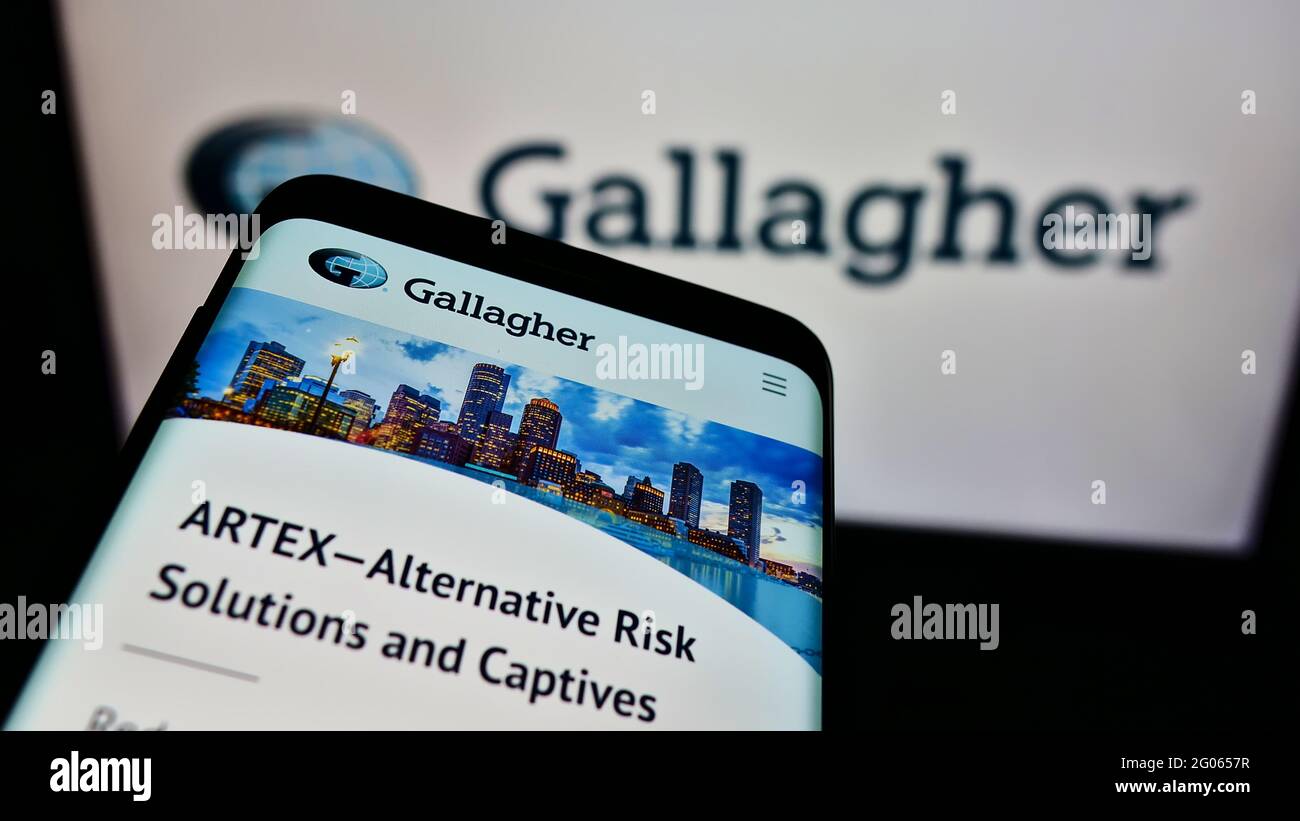 Téléphone mobile avec logo de la compagnie d'assurance américaine Arthur J. Gallagher Co. Sur l'écran devant le site Web. Faites la mise au point dans le coin supérieur gauche de l'écran du téléphone. Banque D'Images