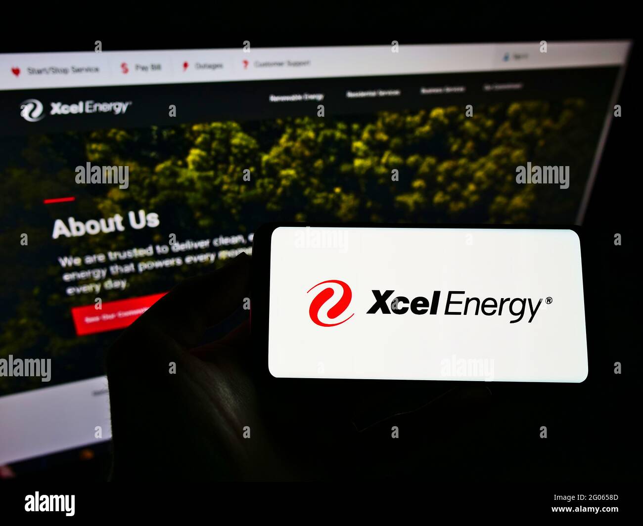 Personne tenant un smartphone avec le logo de la société de services publics américaine Xcel Energy Inc. À l'écran devant le site Web. Mise au point sur l'affichage du téléphone. Banque D'Images