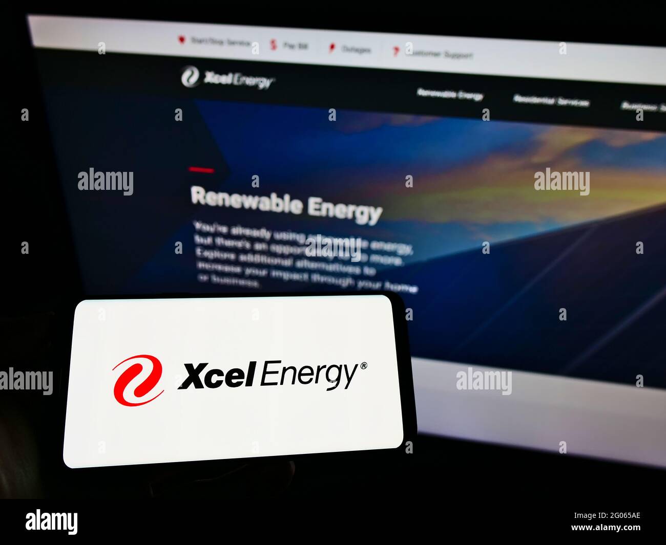Personne tenant un téléphone portable avec le logo de la société de services publics américaine Xcel Energy Inc. À l'écran devant le site Web d'affaires. Mise au point sur l'affichage du téléphone. Banque D'Images