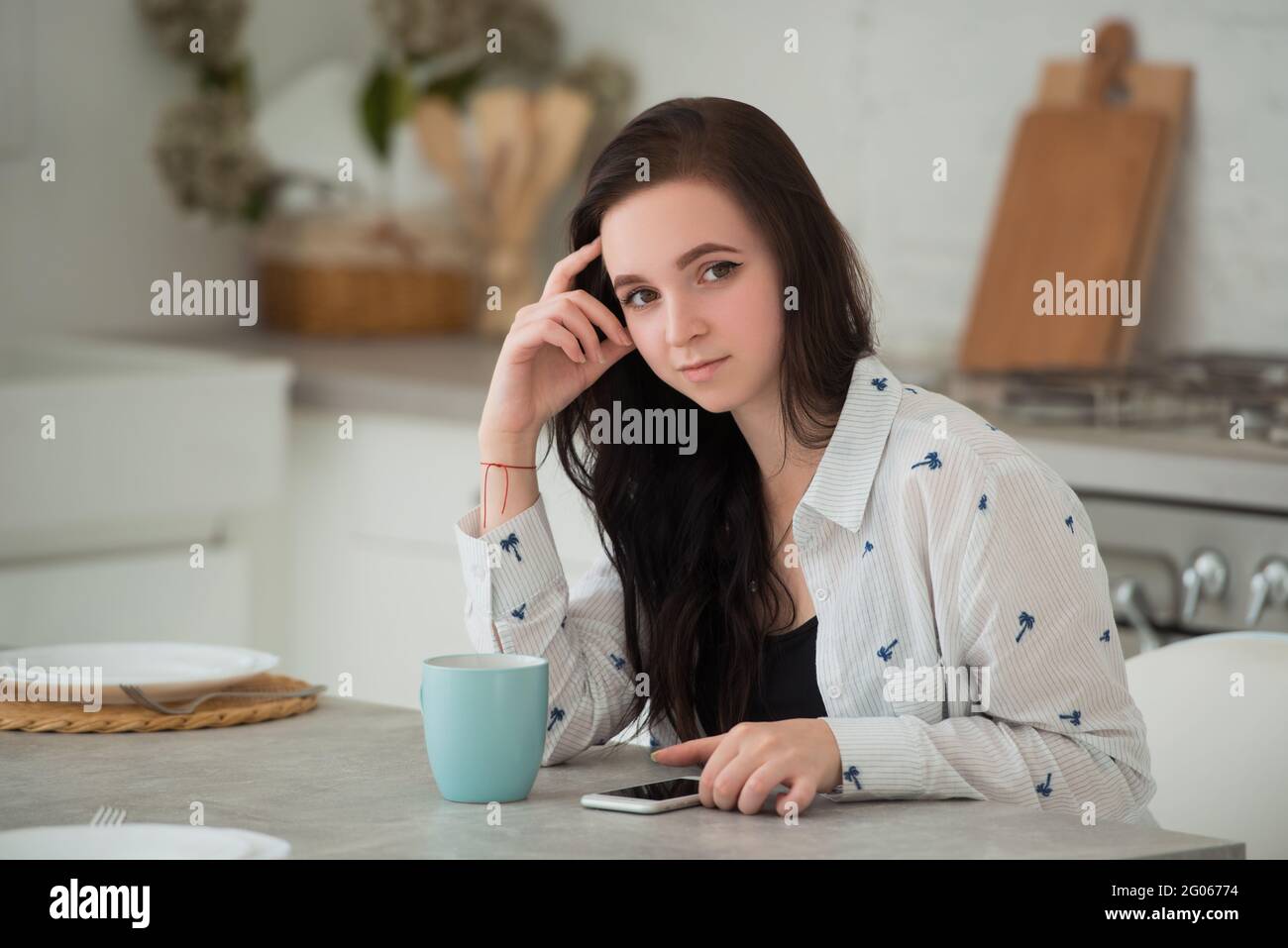 Jeune femme brune étudiante avec téléphone mobile. Réseaux sociaux, smartphones et gadgets modernes comme moyen de communication et d'activités de loisirs Banque D'Images