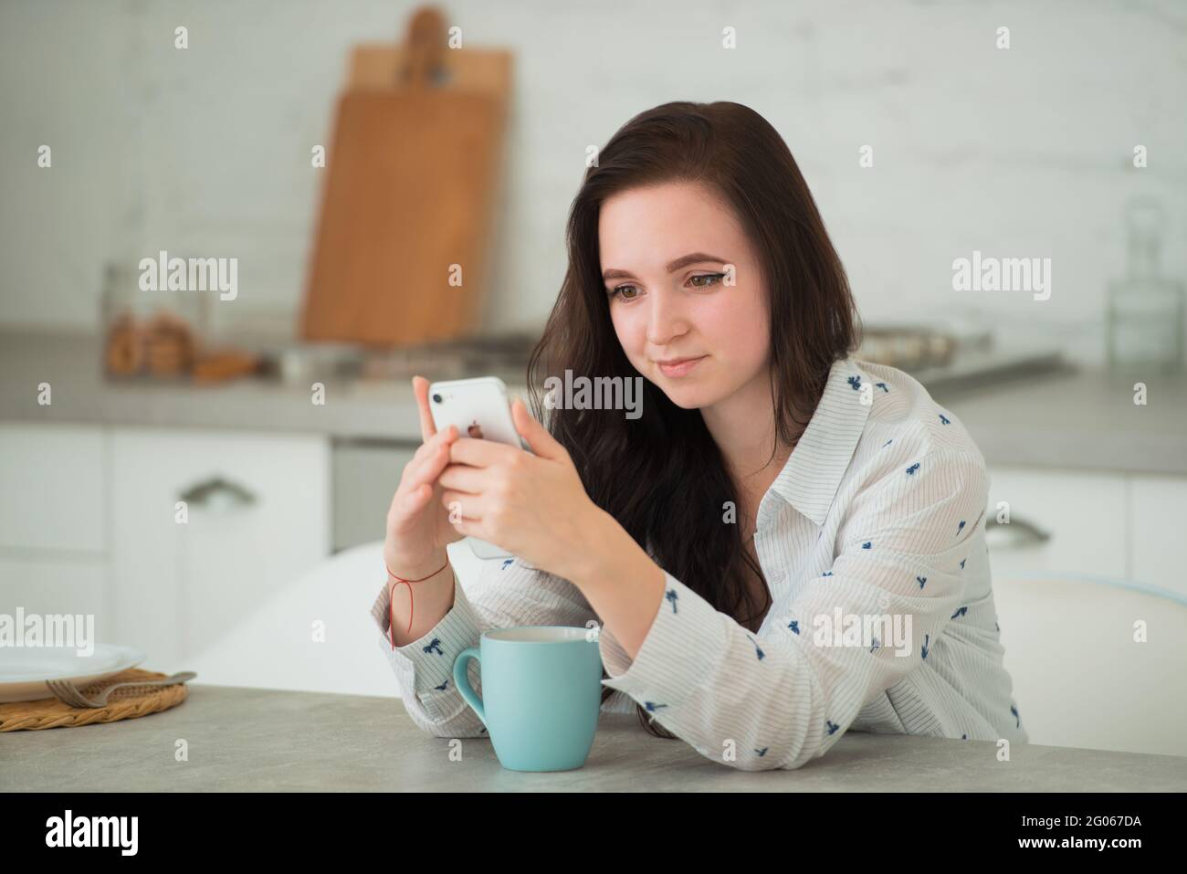 Jeune femme brune étudiante avec téléphone mobile. Réseaux sociaux, smartphones et gadgets modernes comme moyen de communication et d'activités de loisirs Banque D'Images