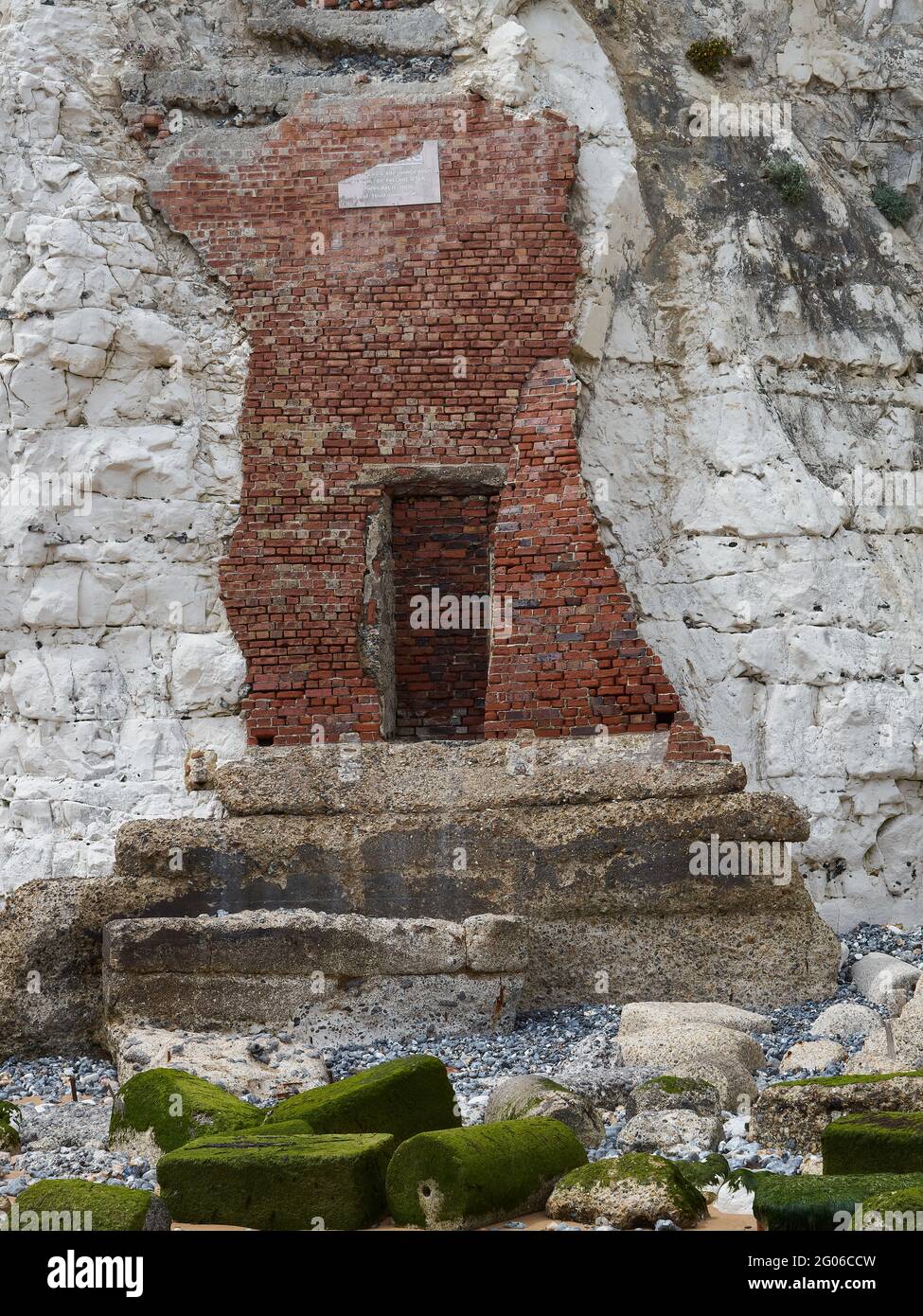 Une porte mystérieuse dans un mur de briques, greffée sur le rocher vivant de la falaise de craie à Stone Bay, avec des gravats et un escalier en dessous. Pourquoi?! Banque D'Images