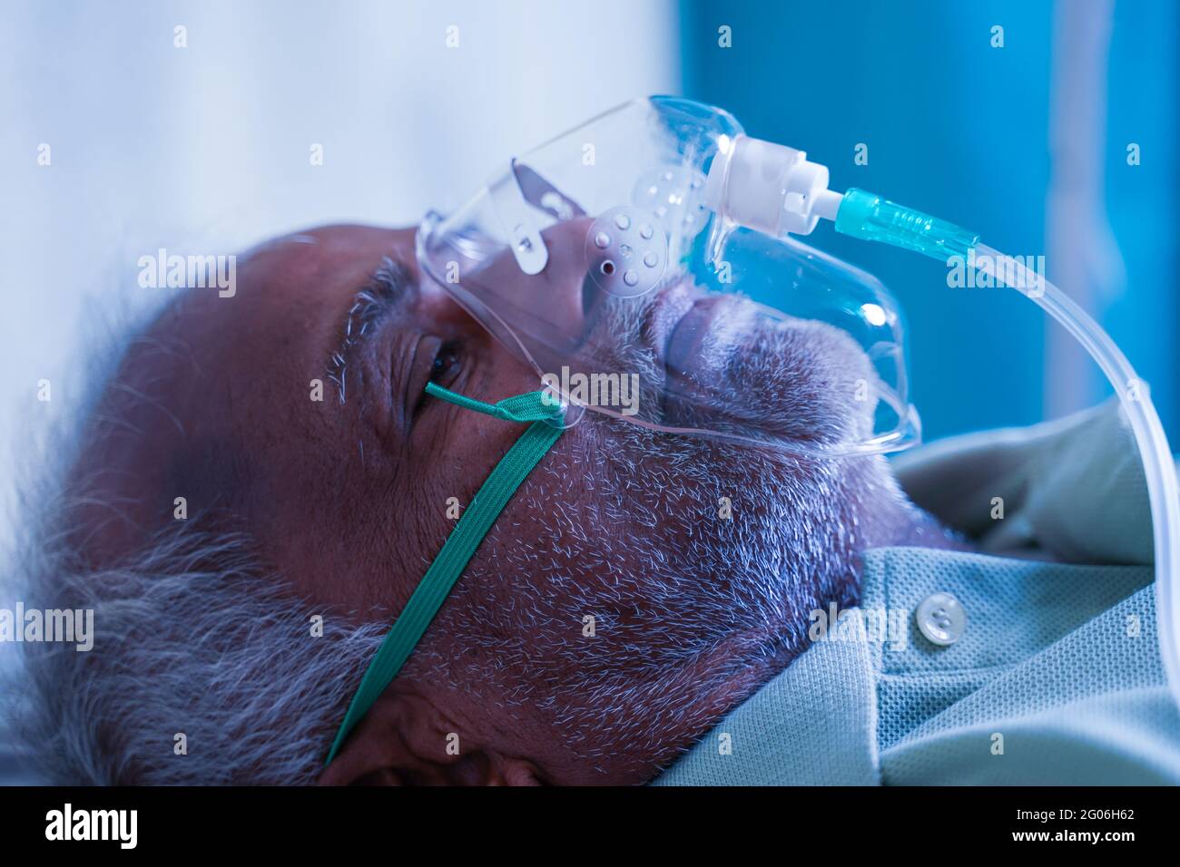 Gros plan vue de côté de l'homme qui respire avec masque à oxygène sous ventilation à l'hôpital en raison d'une infection pulmonaire par le coronavirus Covid-19, essoufflement Banque D'Images