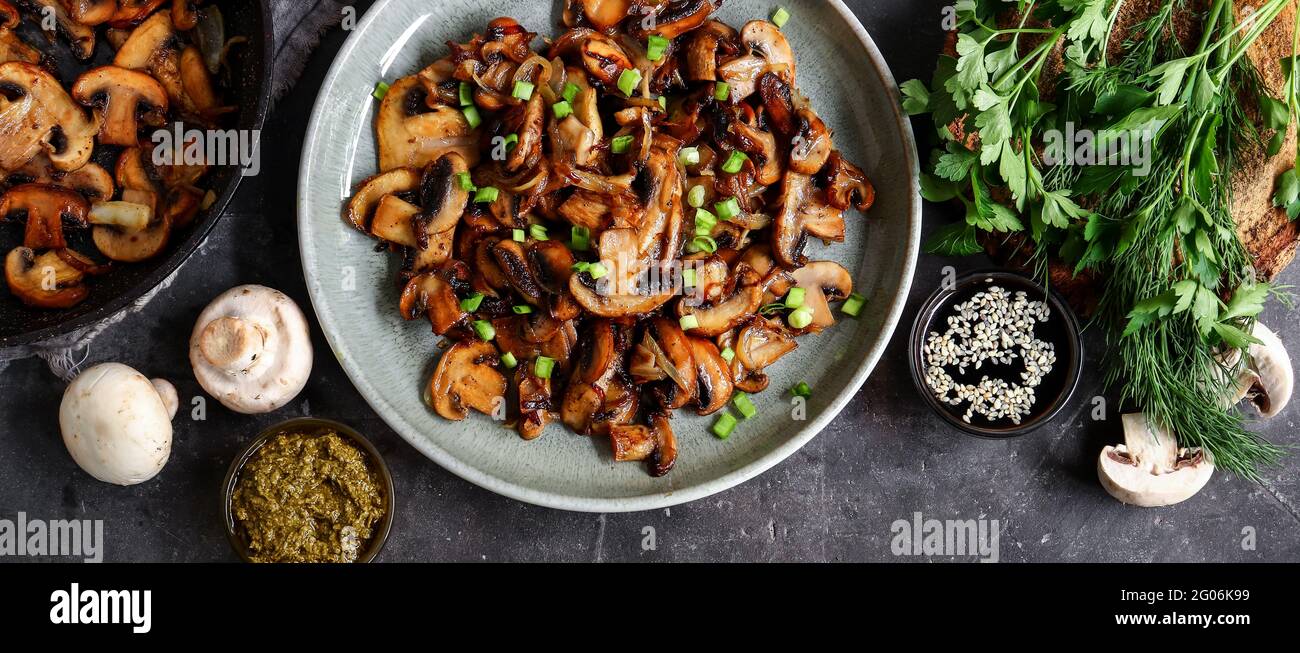 Champignons grillés à l'oignon dans une poêle à frire sur fond de bois, vue du dessus Banque D'Images