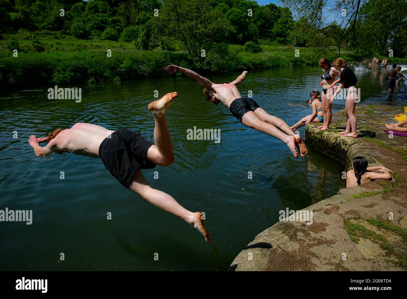 Les nageurs plongent dans l'eau en profitant du temps chaud à Warleigh Weir, Bath, le premier jour de l'été météorologique. Date de la photo: Mardi 1er juin 2021. Banque D'Images