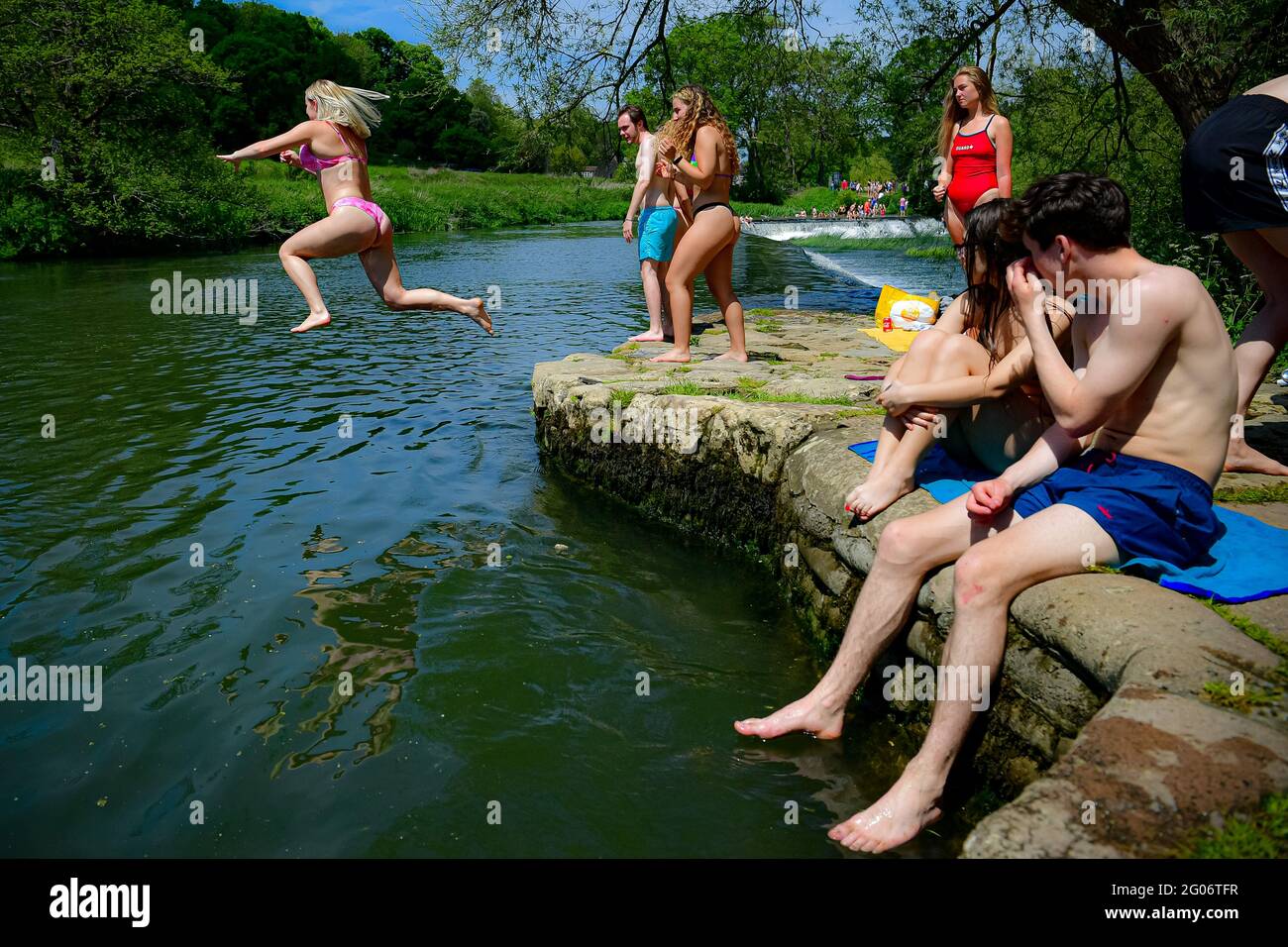 Une femme saute dans l'eau tandis que les gens apprécient le temps chaud à Warleigh Weir, Bath, le premier jour de l'été météorologique. Date de la photo: Mardi 1er juin 2021. Banque D'Images