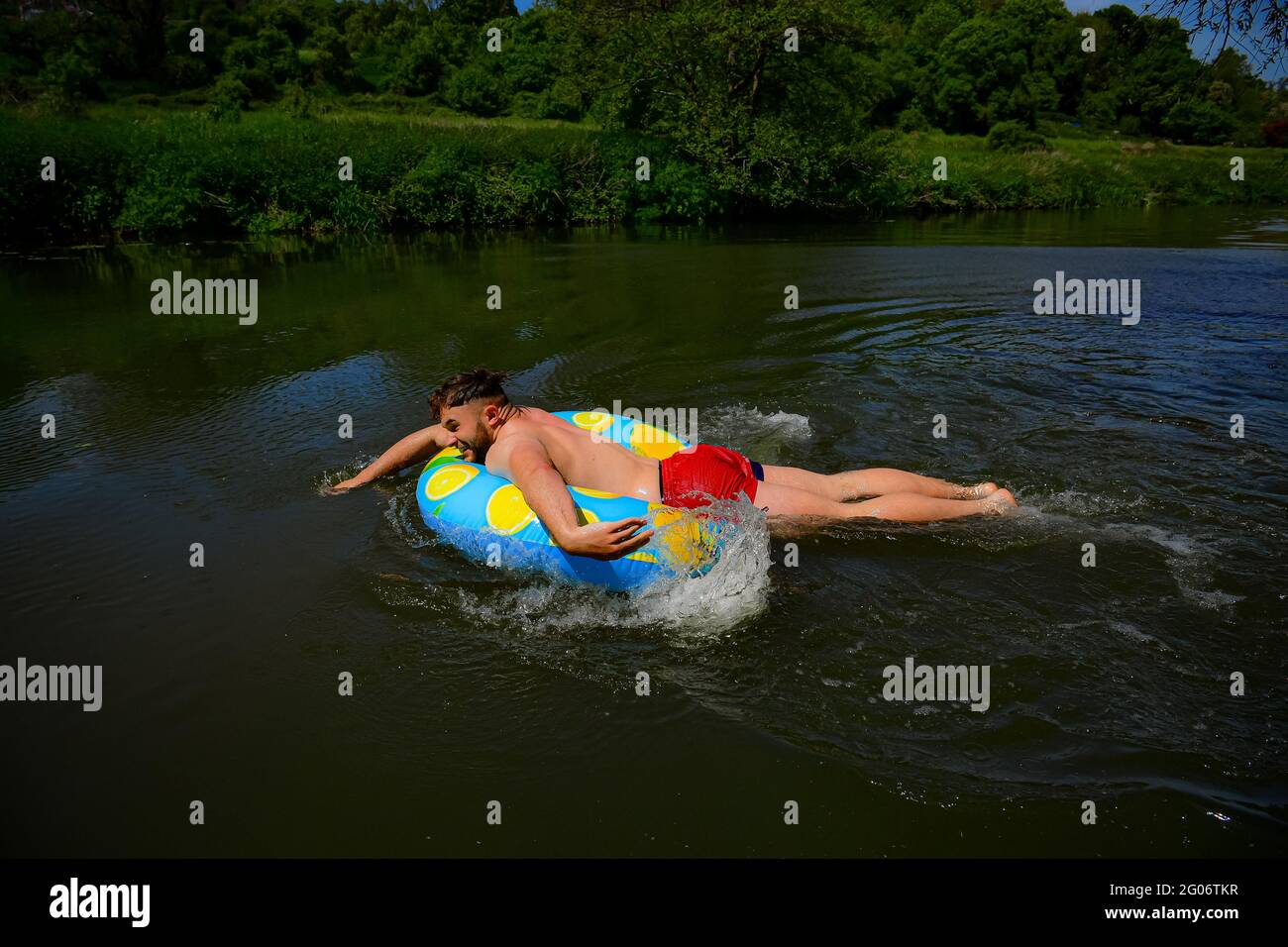 Un homme pagaie un anneau en caoutchouc par temps chaud à Warleigh Weir, Bath, le premier jour de l'été météorologique. Date de la photo: Mardi 1er juin 2021. Banque D'Images