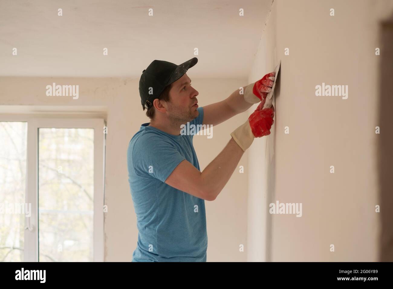 Homme avec un couteau à mastiquer pour réparer le mur à plat Photo Stock -  Alamy