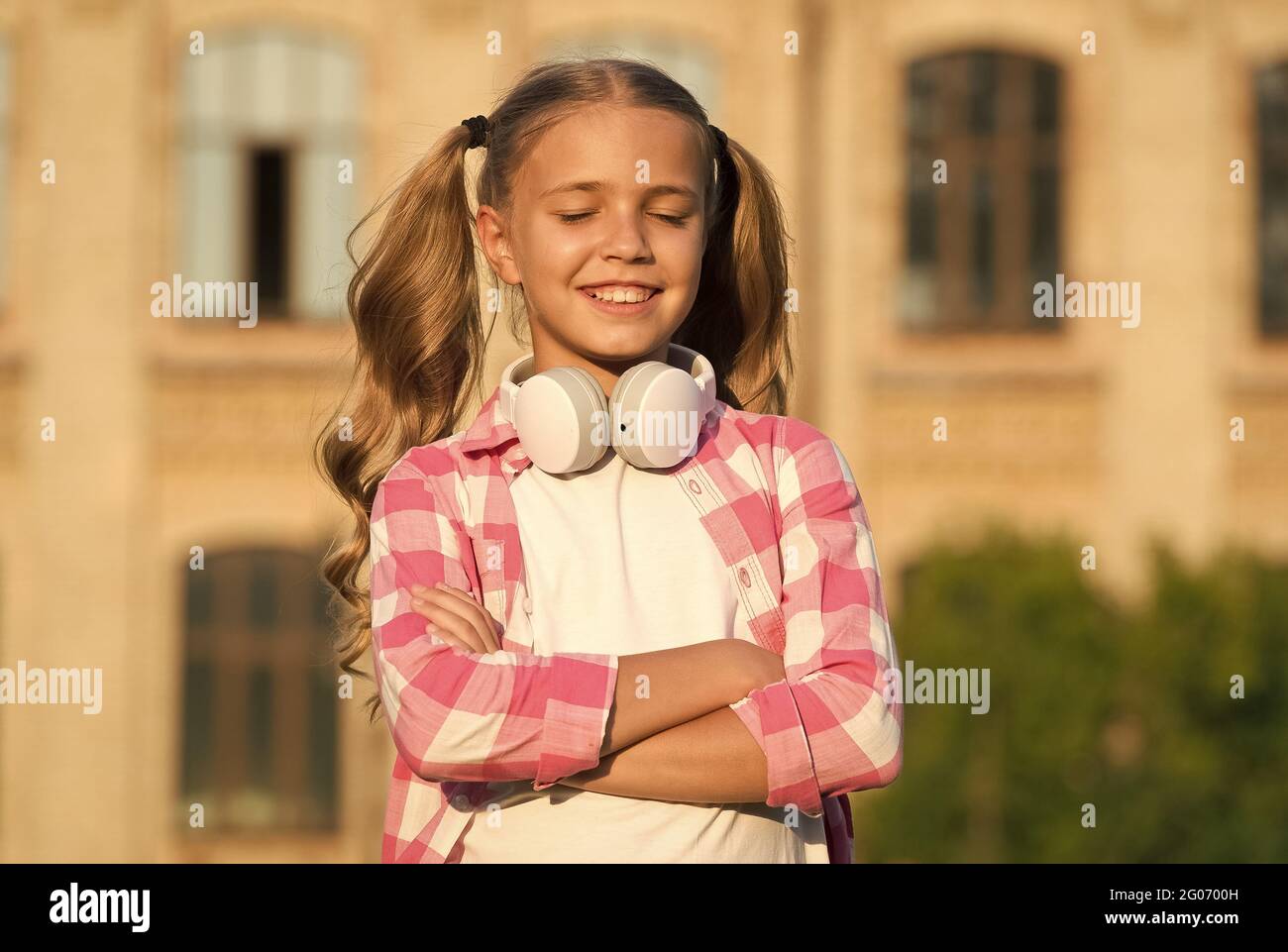 mélomane. petite fille porte une chemise à carreaux. enfant avec micro-casque  au coucher du soleil. enfant printemps et mode été. enfance heureuse.  e-learning avec Photo Stock - Alamy