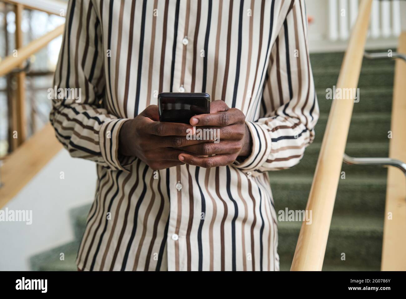 Gros plan de l'homme envoyant un message texte en ligne sur un téléphone portable Banque D'Images