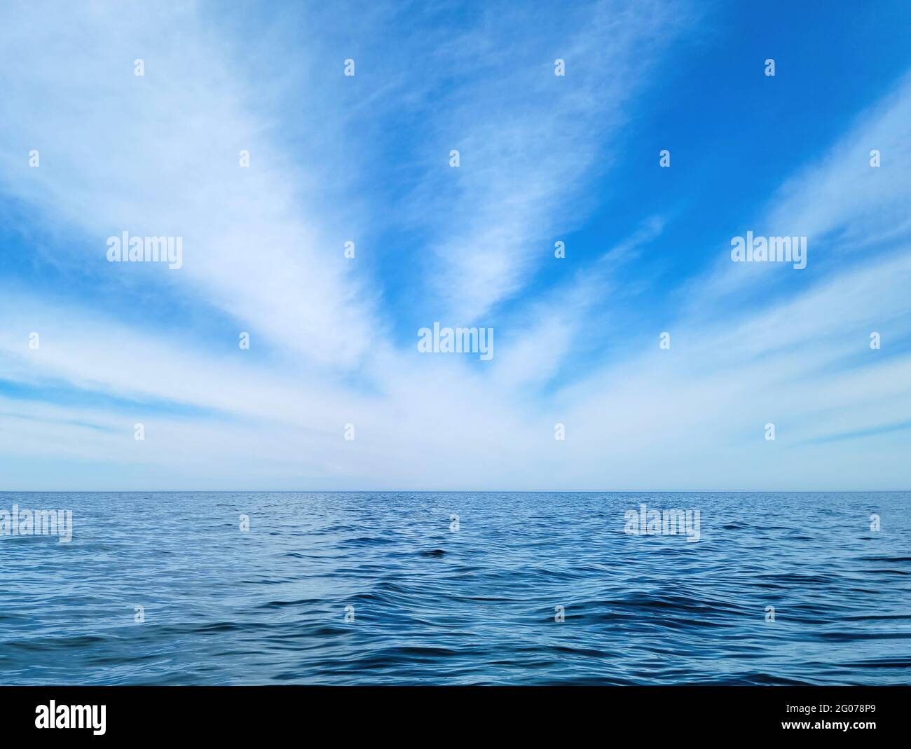 Motif d'explosion de nuages blancs et wispy dans un ciel bleu au-dessus de l'eau calme du lac Michigan Banque D'Images Motif d'explosion de nuages blancs et wispy dans un ciel bleu au-dessus de l'eau calme du lac Michigan Banque D'Images