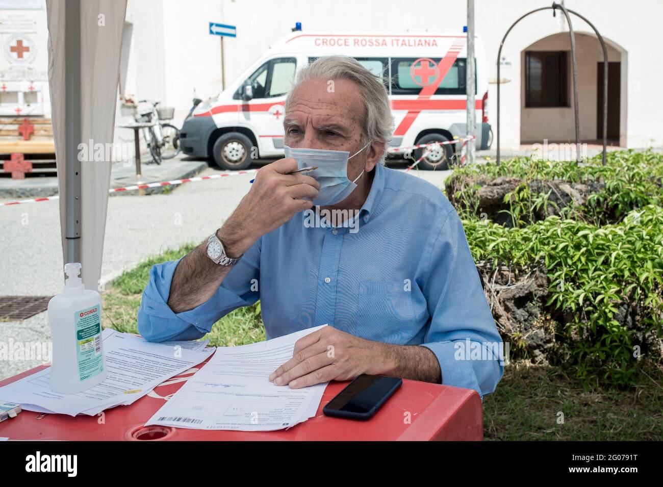 Le Dr Basile a été vu au cours d'un entretien d'anamnèse avec un bénéficiaire du vaccin Covid-19 au centre médical.la vaccination de masse a commencé sur l'île Vulcano sous la direction de l'équipe de la région de Sicilia, le Commissaire spécial pour l'urgence Covid-19 pour la région métropolitaine de Messine (Ufficio Commissario ad Acta per l’Emergenza Covid-19 per l’Area Metropolitana di Messina) et l’équipe locale de la Croix-Rouge. Des doses de vaccins Moderna et Johnson & Johnson ont été administrées aux résidents afin de mettre en œuvre le programme « îles sans Covid » pour l'été. Banque D'Images