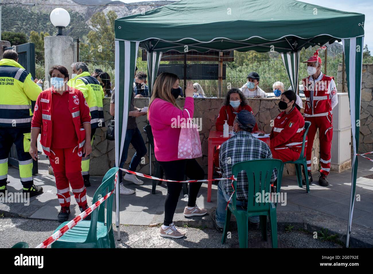 Les membres de la Croix-Rouge attendent à l'entrée du centre médical pour enregistrer les personnes pour les tirs de vaccin Covid-19 à Vulcano.la vaccination de masse a commencé sur l'île de Vulcano sous la direction de l'équipe de la région de Sicilia, le Commissaire spécial pour l'urgence de Covid-19 pour la zone métropolitaine de Messine (Ufficio Commissario ad Acta per l’Emergenza Covid-19 per l’Area Metropolitana di Messina) et l’équipe locale de la Croix-Rouge. Des doses de vaccins Moderna et Johnson & Johnson ont été administrées aux résidents afin de mettre en œuvre le programme « îles sans Covid » pour l'été. Banque D'Images