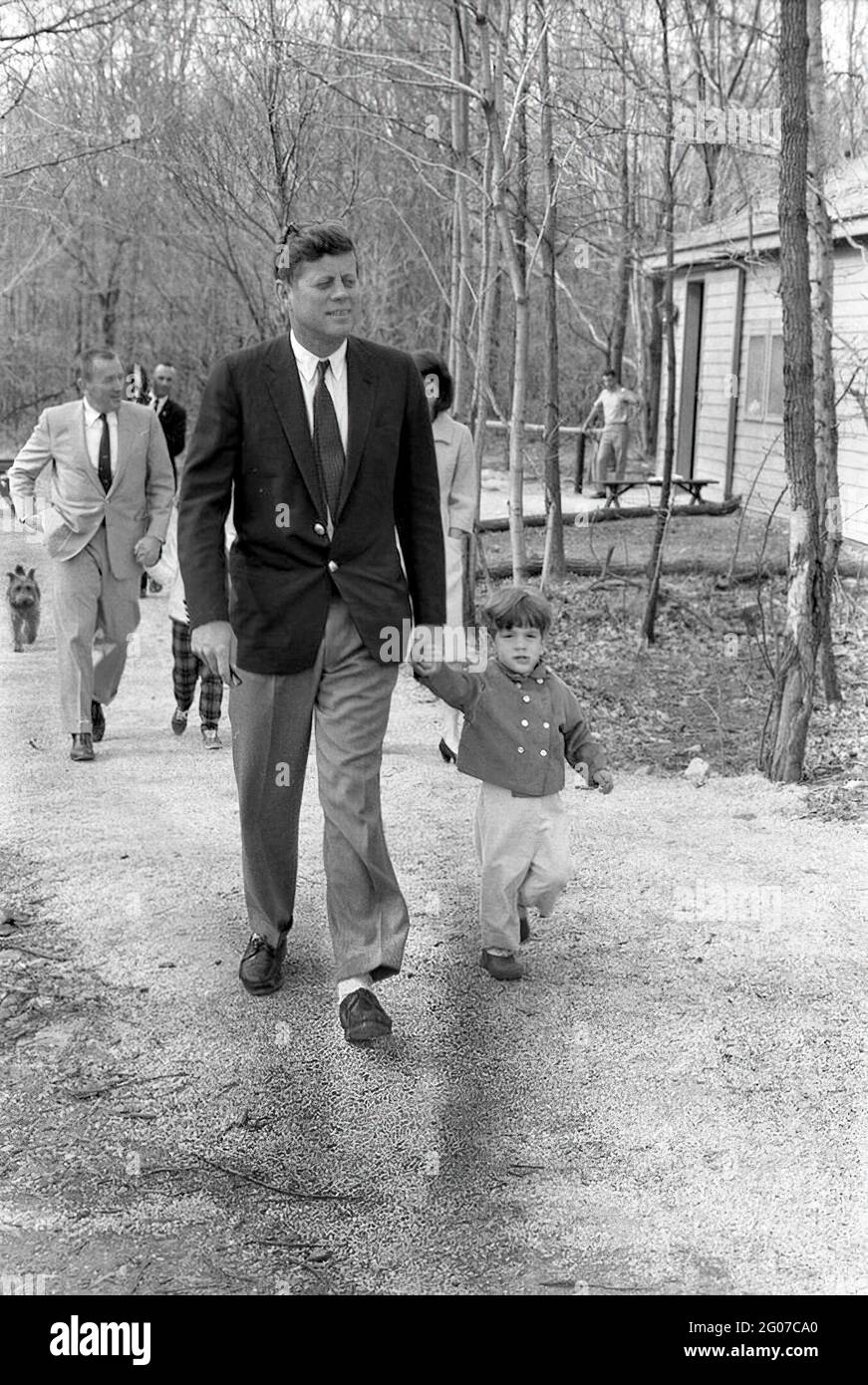 31 mars 1963 week-end au Camp David. Le président John F. Kennedy et son  fils John, Jr. Marchent sur un chemin pendant un week-end au Camp David.  Également en photo : la
