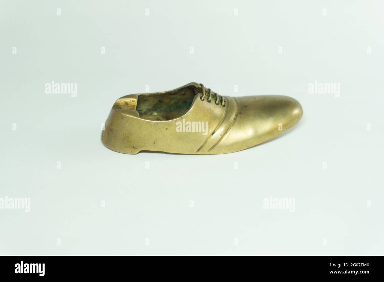 Gros plan d'un cendrier en forme de chaussure en laiton doré, sur fond  blanc Photo Stock - Alamy
