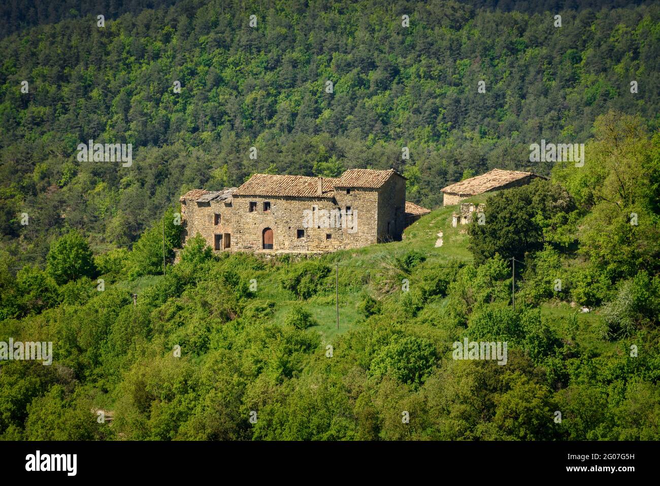 Les environs de Santa Llúcia de Sobrémunét au printemps. Mas Conjunta maison de campagne en premier plan et Montserrat en arrière-plan (Catalogne, Espagne) Banque D'Images