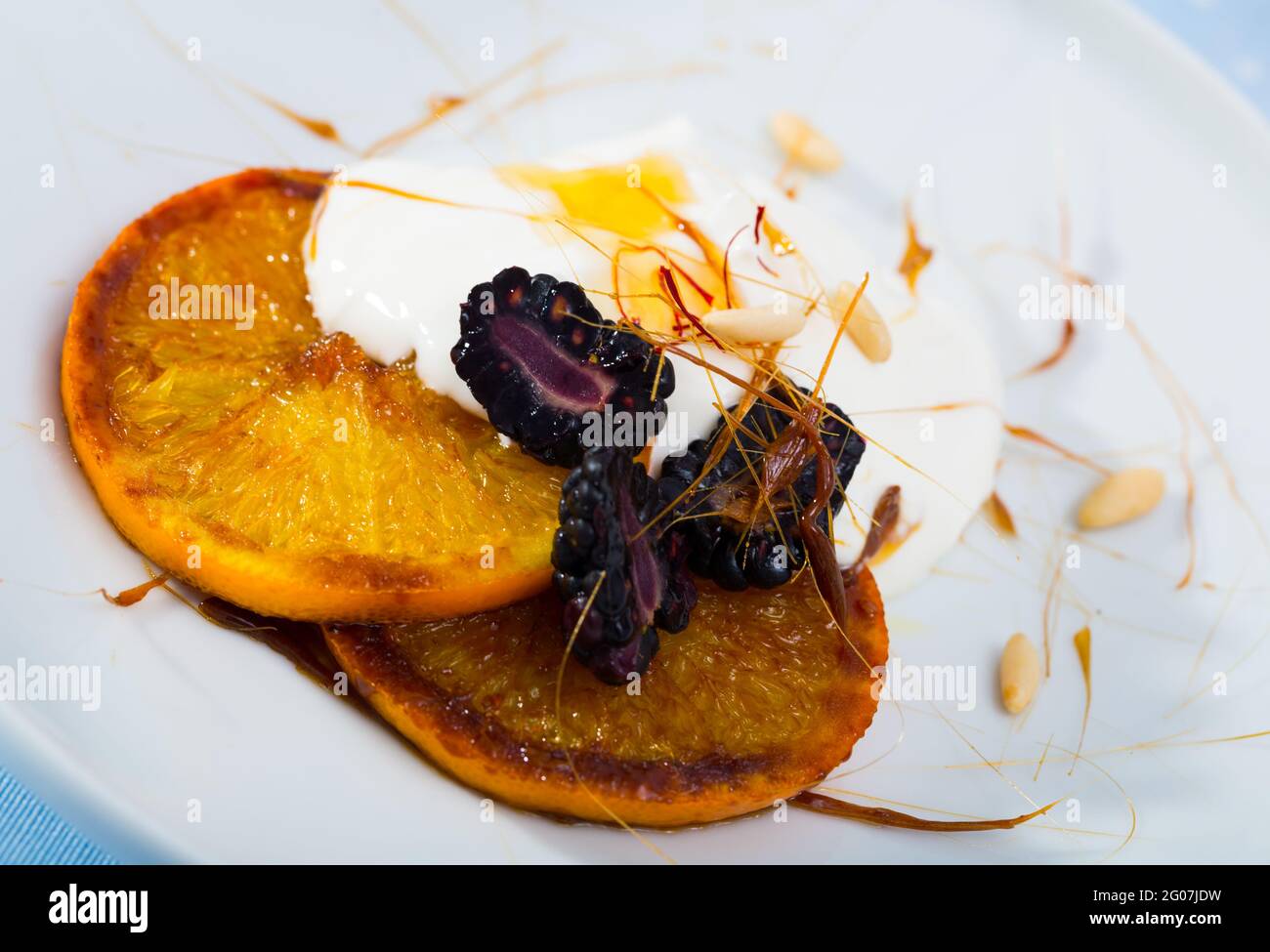 Dessert d'oranges caramélisées, de mûres et de yaourts Banque D'Images