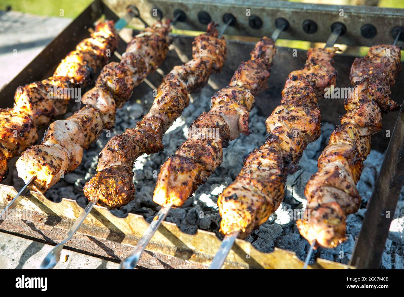 Shashlik ou shish kebab préparation sur barbecue grill sur charbon chaud. Morceaux de viande de porc grillés sur brochettes de métal. Banque D'Images