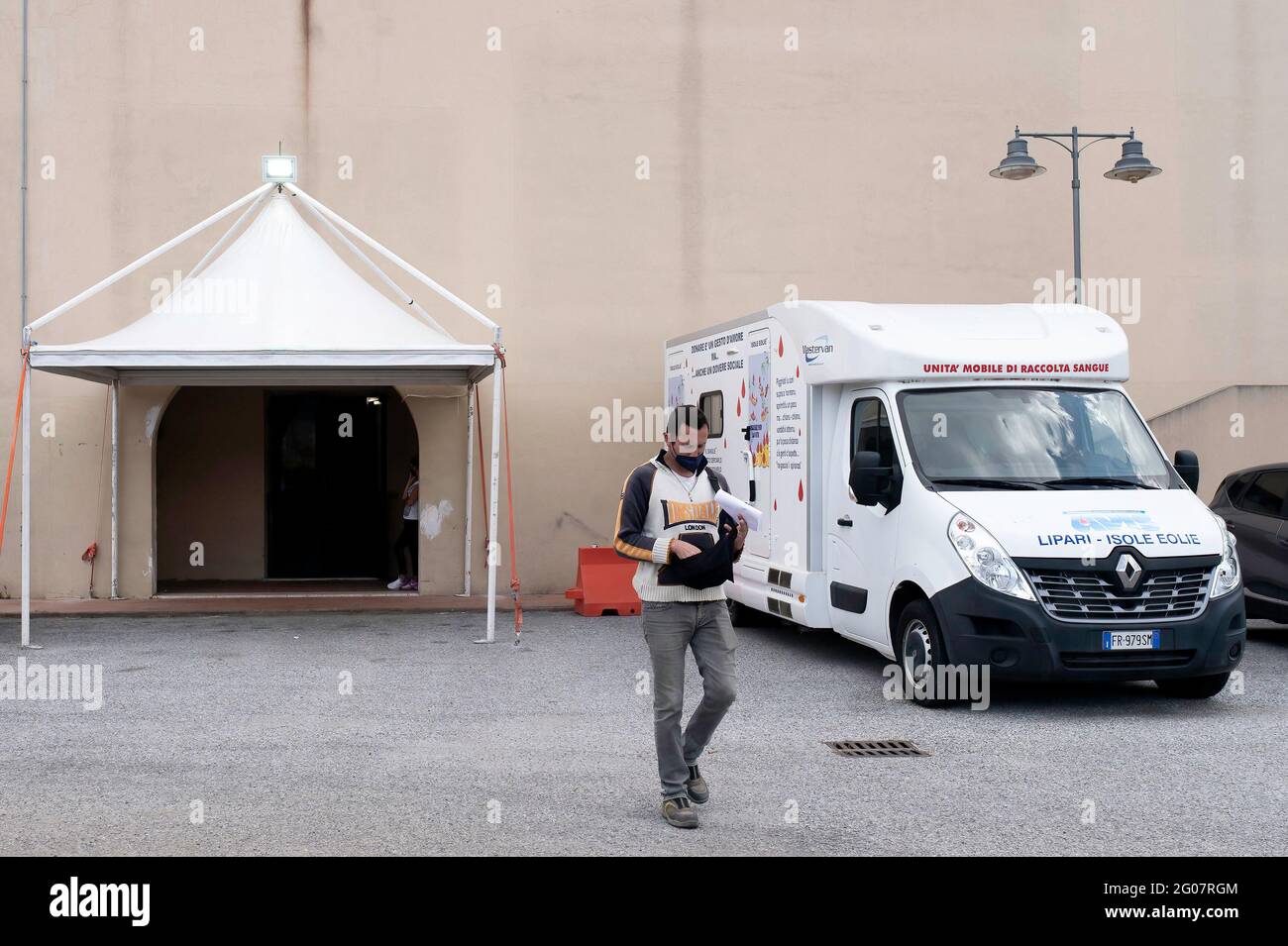 Un homme vu sortir du centre de vaccination. Selon le programme “îles sans Covid” pour l’été, la population de Lipari, la plus importante des îles éoliennes de Sicile, a reçu le vaccin anti COVID-19 au Palais des Congrès. Le programme a été exécuté par une équipe de la région sicilienne, sous la direction du Commissaire spécial pour l’urgence Covid-19 de la zone métropolitaine de Messine (Ufficio Commissario ad Acta per l’Emergenza Covid-19 per l’Area Metropolitana di Messina) et avec l’aide de la Marine italienne. Banque D'Images