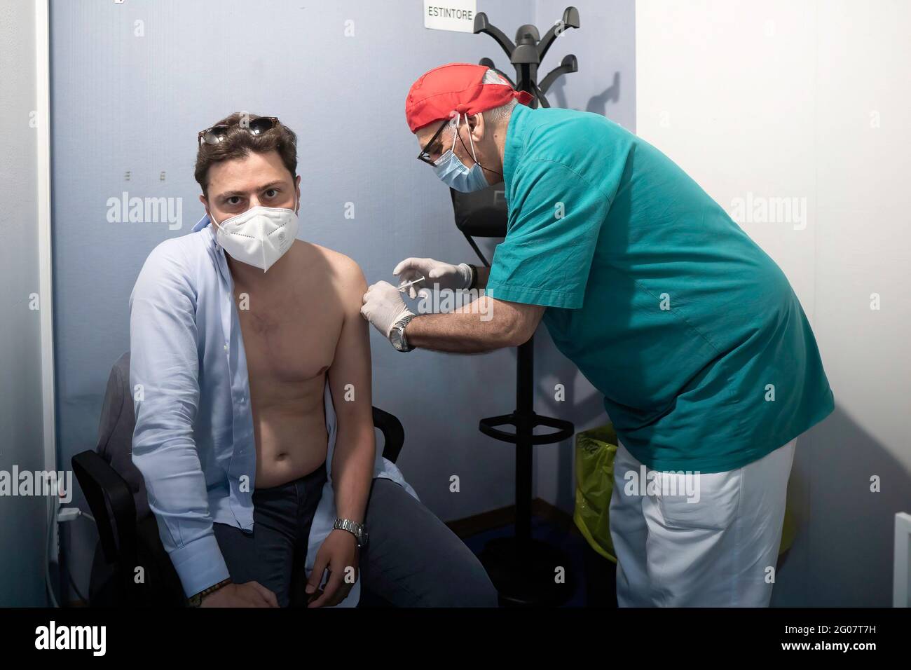 Lipari, Sicile, Italie. 14 mai 2021. Un agent de santé administre une dose de vaccin contre le coronavirus (Covid-19) à un homme au Centre des congrès.selon le programme « îles sans Covid » pour l'été, la population de Lipari, la plus importante des îles éoliennes de Sicile, a reçu le vaccin anti COVID-19 au Centre des congrès (Palazzo dei Congressi). Le programme a été exécuté par une équipe de la région sicilienne, sous la direction du Commissaire spécial pour l'urgence Covid-19 de la zone métropolitaine de Messine (Ufficio Commissario ad Acta per l'Emergenza Covid-19 per l'Area Metropo Banque D'Images