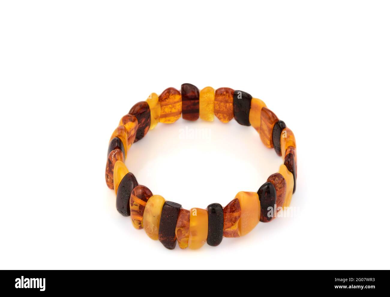 Bracelet en perles d'ambre de luxe au miel transparent poli naturel avec inclusions sur blanc. Gros plan sélectif de la mise au point douce. Espace pour le texte Banque D'Images