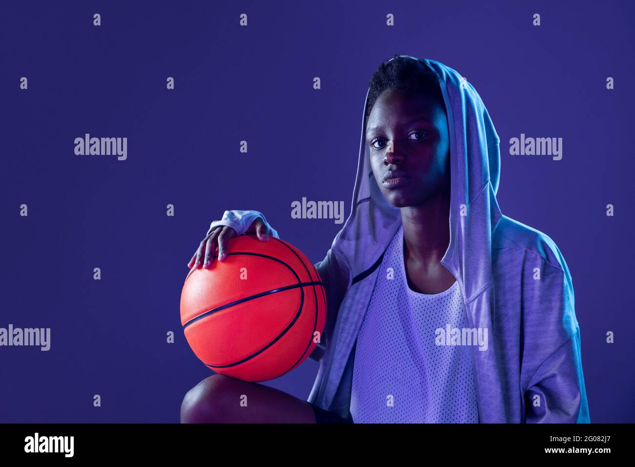 Femme noire avec tenue de basket ball dans le studio utilisant des gels de couleur et des projecteurs Photo Stock Alamy