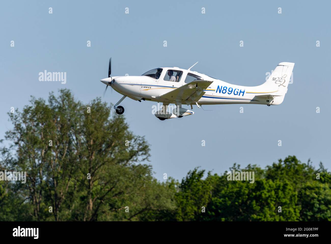 L'avion léger SR22 de Cirrus N89GH volant dans un ciel bleu à l'aérodrome de Stapleford, Essex, Royaume-Uni. Escalade après décollage. Avion américain enregistré Banque D'Images
