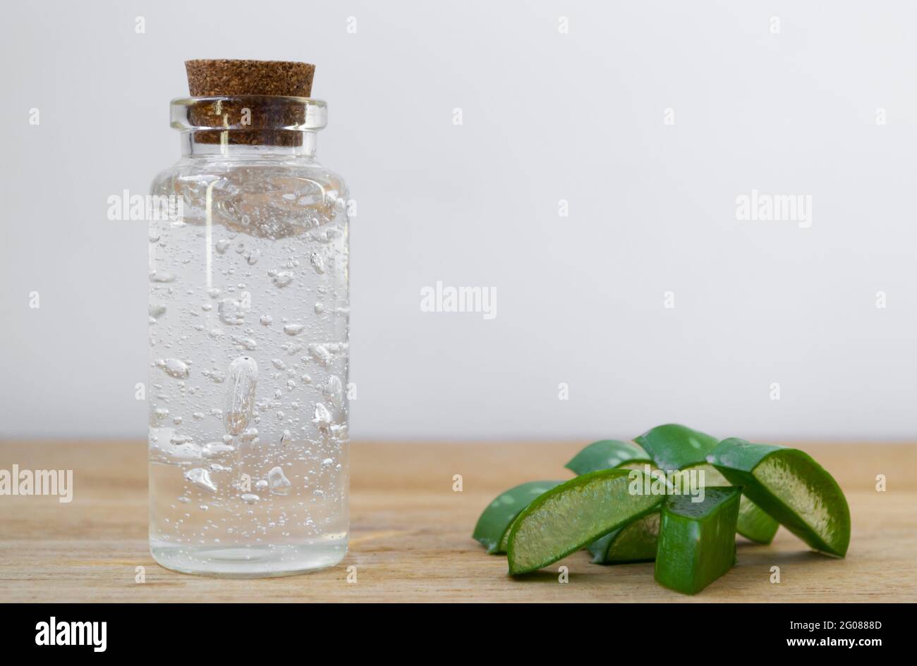 Bouteille en verre de gel d'aloe vera avec morceaux de feuilles de plantes  sur fond en bois Photo Stock - Alamy