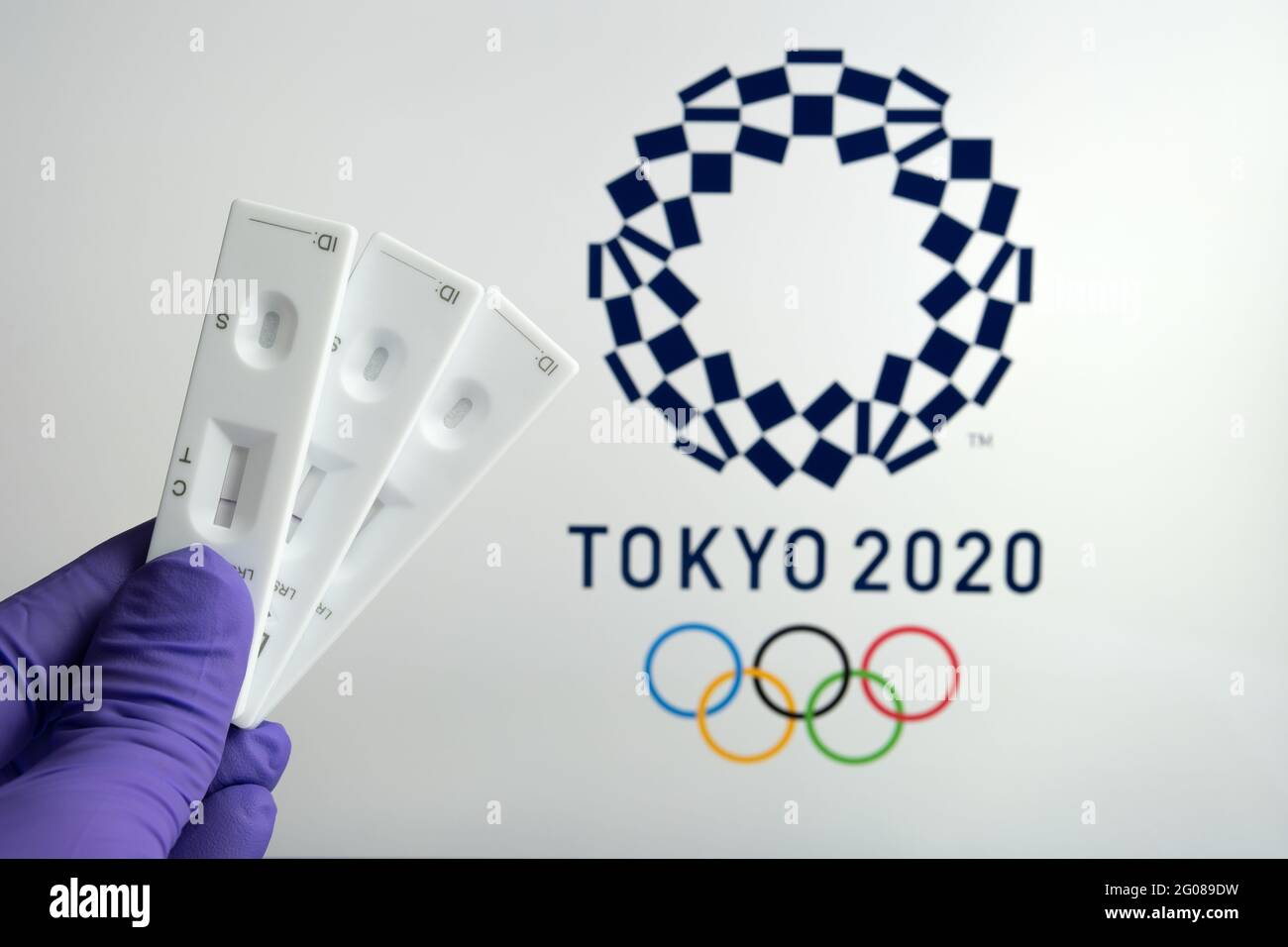 Test PCR négatif à l'avant et logo Tokyo 2020 flou sur fond flou. Concept pour les Jeux Olympiques de Tokyo COVID en 2021. Stafford, United King Banque D'Images