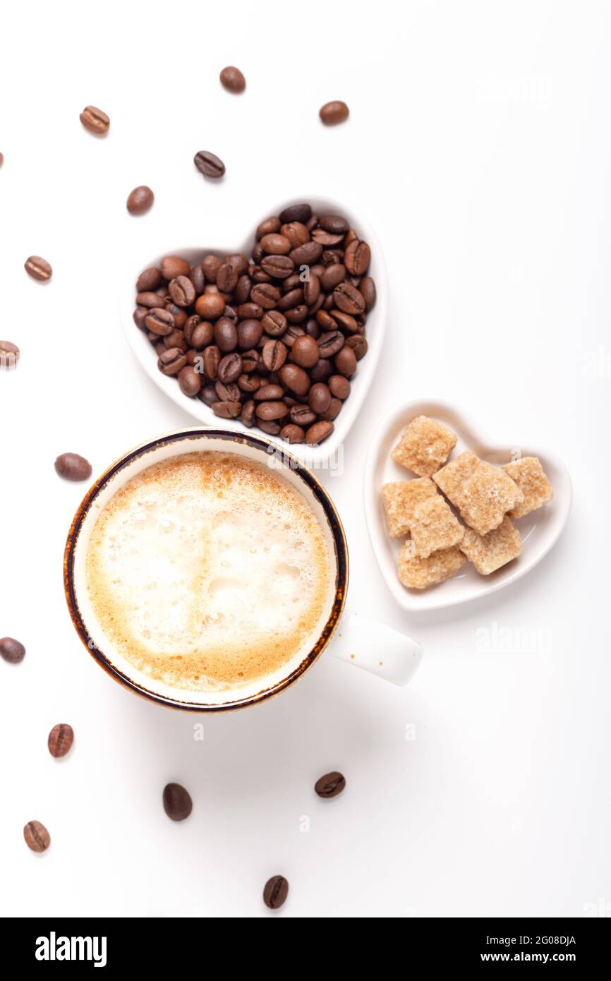 Tasse avec café et assiettes en forme de coeur avec grains de café et sucre brun. Vue de dessus. Photo verticale - image Banque D'Images