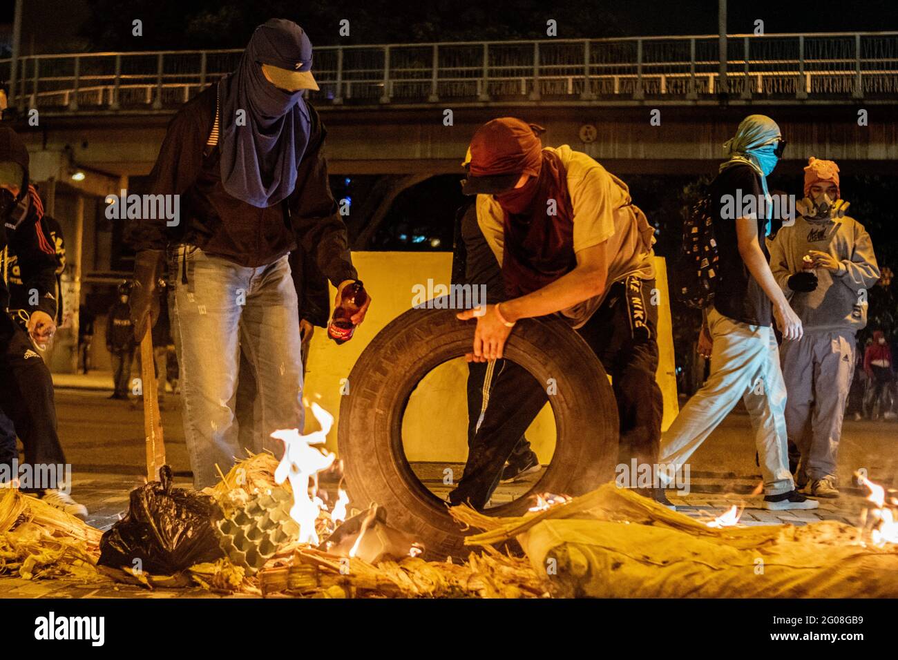 Medellin, Colombie, le 31 mai 2021. Les manifestants font une barricade avec des pneus brûlés et des déchets pour empêcher l'approche de camions blindés anti-émeute et les effets des gaz lacrymogènes lorsqu'un groupe de manifestants à capuchon se heurte à la police anti-émeute de Colombie (ESMAD) à Medellin, Colombie lors des manifestations anti-gouvernementales en cours contre la réforme fiscale et sanitaire du président Ivan Duque et les brutalités et troubles de la police qui ont fait au moins 70 morts au cours du mois dernier, à Medellin, en Colombie, le 31 mai 2021. Banque D'Images