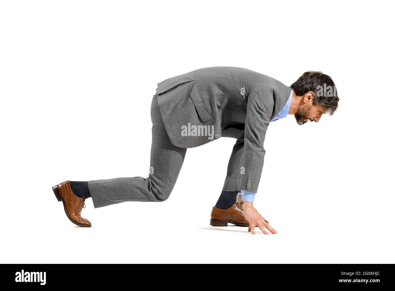 Homme d'affaires élégant en costume en position de départ pour une course en avant prêt à courir dans un défi, une opportunité, une ambition ou un co de compétition Banque D'Images