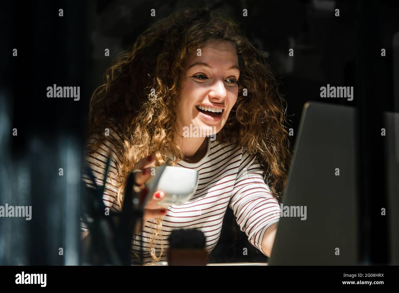 Bonne femme caucasienne souriante regardant un ordinateur portable parlant sur appel vidéo à la maison tôt le matin Banque D'Images