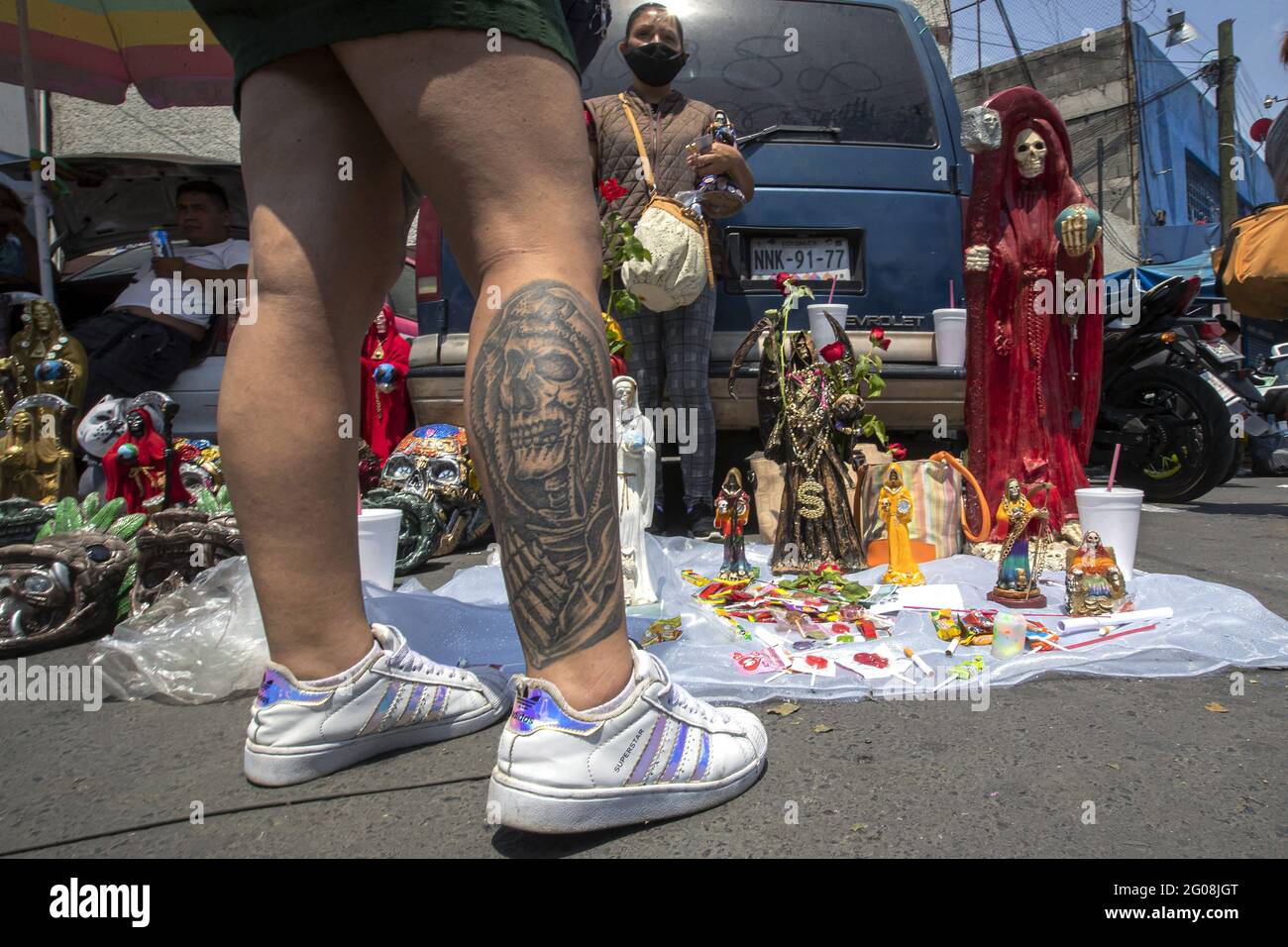 Un fidèle avec un tatoo de Santa Muerte, en arrivant à l'autel de Santa Muerte dans la ville de Tepito, dans le cadre des célébrations qui ont eu lieu le premier jour de chaque mois, des centaines de dévotés s'y rendent pour le vénérer, remerciez pour les faveurs et les promesses tenues que cette déité leur a accordées. La Santa Muerte ou Santisima Muerte est une figure mexicaine populaire qui personnifie la mort et est un objet de culte, les dévotés d'elle sont généralement perçus comme des personnes associées à la criminalité, l'activité des gangs, la prostitution, le trafic de drogue. Mexico, Mexique, 1er juin 2021. Photo de Ricardo F. Banque D'Images