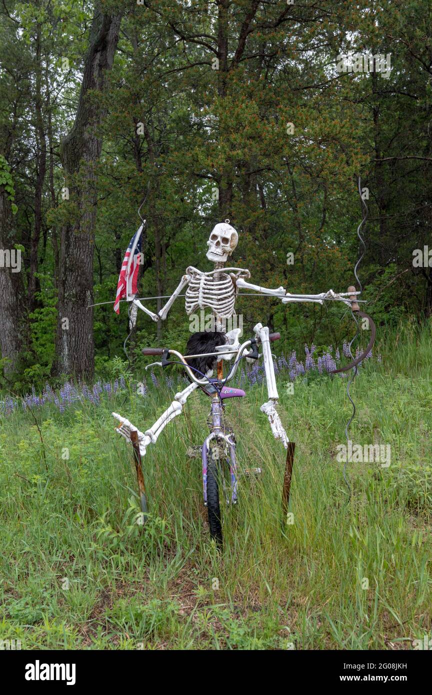 Un squelette porte un drapeau américain tout en faisant du vélo Banque D'Images