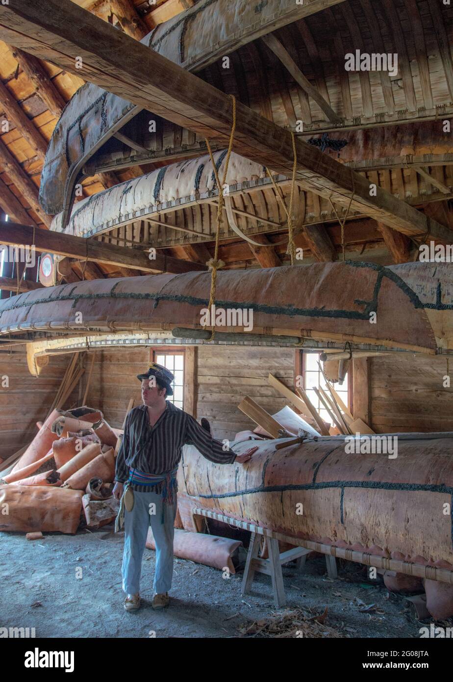 Un interprète historique en costume de traite des fourrures parle des canoës traditionnels en écorce d'oiseau à fort William, près de Thunder Bay, en Ontario Banque D'Images