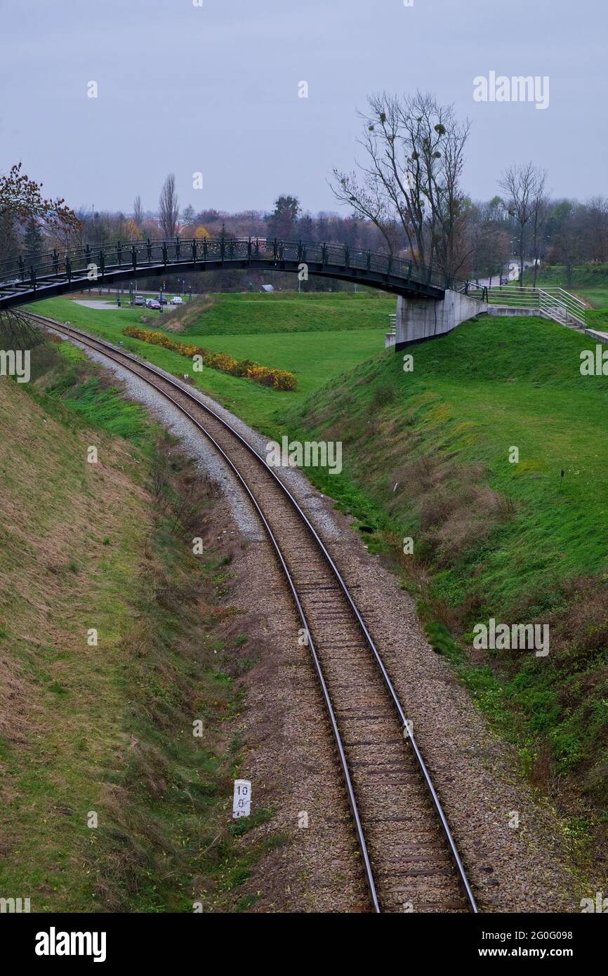 Petite passerelle au-dessus de la voie ferrée lors d'une journée d'automne nuageux. Rails près de la ville polonaise de Zamosc. Banque D'Images