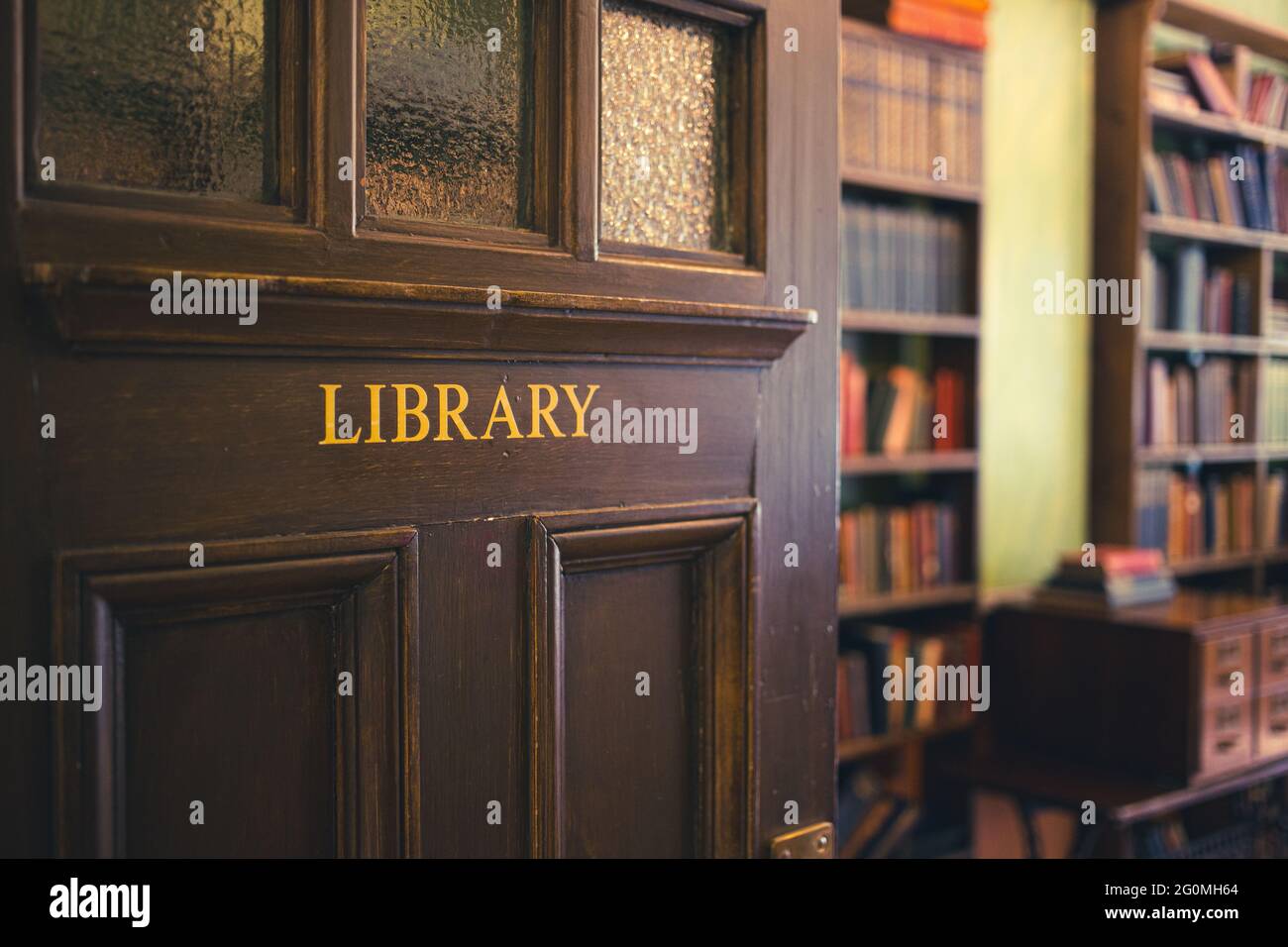 Ancien style début du XIXe siècle, porte de bibliothèque en bois teinté foncé incrustée de panneaux de verre dépoli, menant à une ancienne bibliothèque Banque D'Images