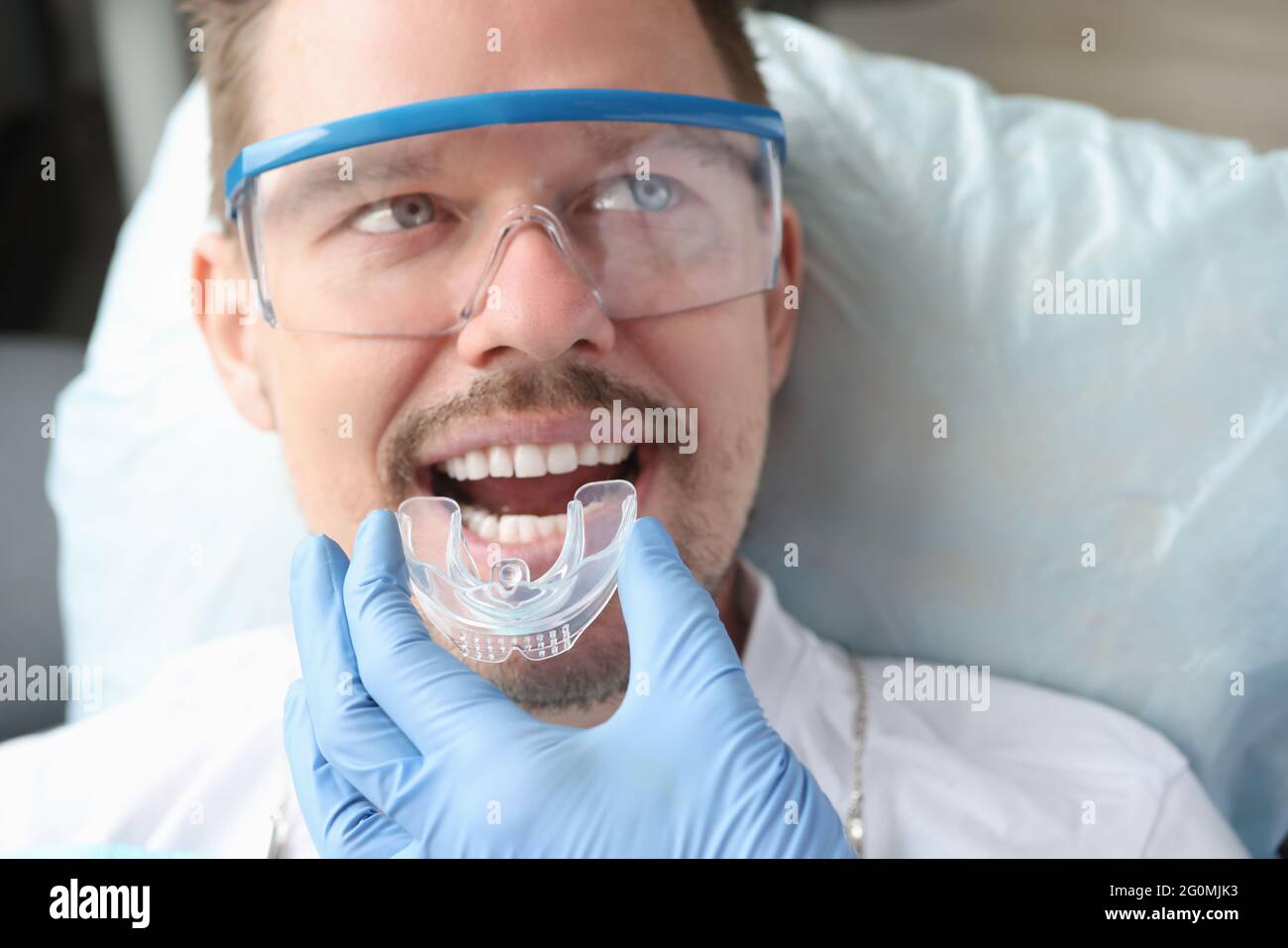 Dentiste essayant sur le protecteur buccal pour homme patient Banque D'Images