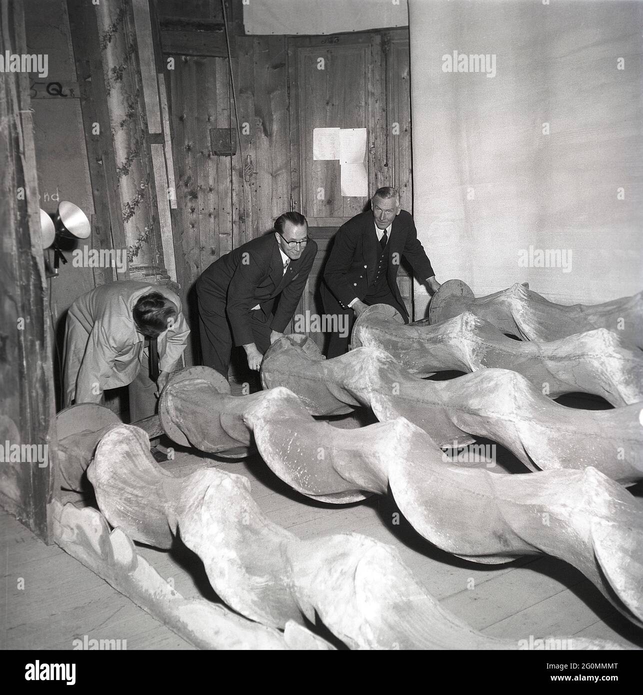 Dans les coulisses du théâtre des années 1950. Trois hommes opèrent des morceaux de rouleaux étranges mais l'explication est simple, en les roulant et en ayant un gros morceau de tissu sur eux, le mouvement crée l'impression d'une mer et des vagues en mouvement, souvent utilisé comme décoration sur le théâtre. Une machine à vagues. Suède 1953 réf. BM29-11 Banque D'Images